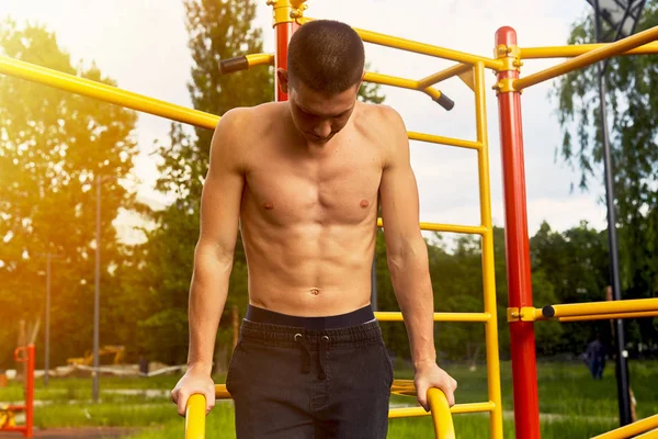 Güçlü adam zor egzersizleri ile sokak egzersiz yapın ve kamera için poz