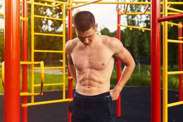 Güçlü adam zor egzersizleri ile sokak egzersiz yapın ve kamera için poz