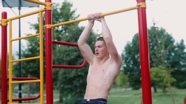 Güçlü adam zor egzersizleri ile sokak egzersiz yapın ve kamera için poz