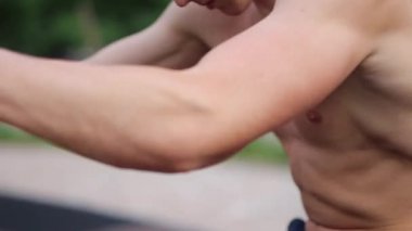 Güçlü adam zor egzersizleri ile sokak egzersiz yapın ve kamera için poz