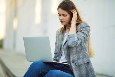Güzel kız oturup onu laptop ve stydy ile. Beyaz arka plan