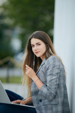 Güzel kız oturup onu laptop ve stydy ile. Beyaz arka plan