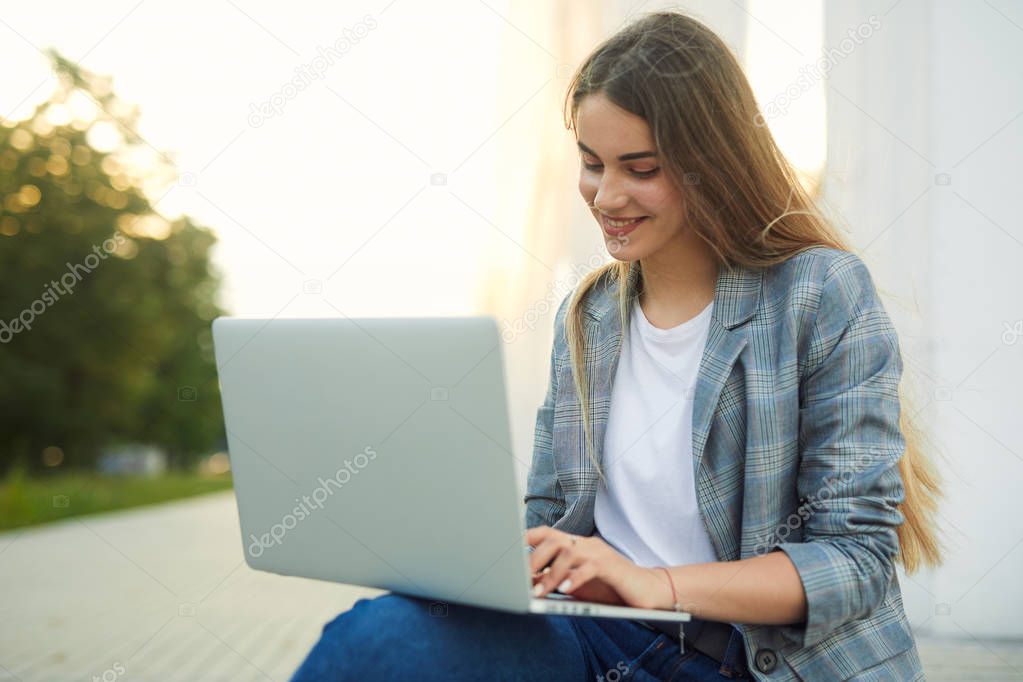 Pretty girl sit with her laptop and stydy. White background