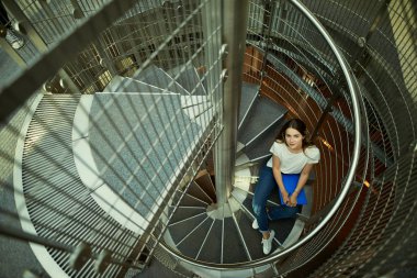 Güzel kız mavi kitap okumak ve kameraya gülümse