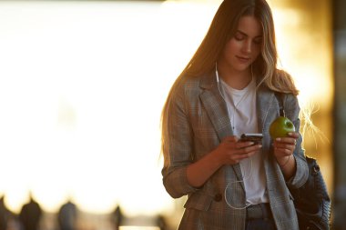 Telefonunu günbatımı arka plan ile güzel kız konuşma