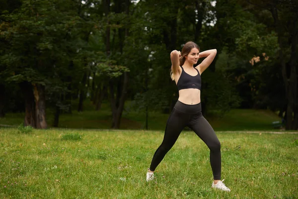 Sportieve Meisje Squats Het Gras — Stockfoto