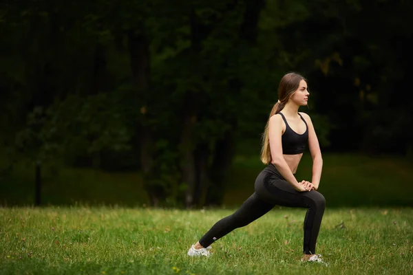 Sporty Girl Squats Grass — Stock Photo, Image