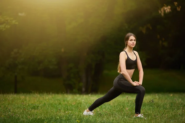 Sportieve Meisje Squats Het Gras — Stockfoto