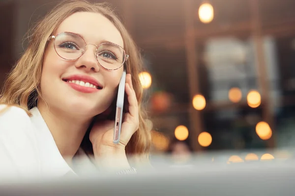 Woman Wear Glasses, Talk At Phone, Drink Her Hot Coffee While Work In Cafe On Her Laptop. Portrait Of Stylish Smiling Woman In Winter Clothes Drinking Hot Coffee And Work At Laptop. Female Winter Style. - Image