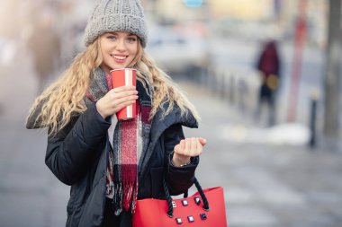 Kadın sokakta yürürken onu sıcak kahve iç. Kışın şık gülümseyen kadın portresi sıcak kahve içme giysiler. Kadın kış Style. -Görüntü