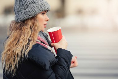 Kadın sokakta yürürken onu sıcak kahve iç. Kışın şık gülümseyen kadın portresi sıcak kahve içme giysiler. Kadın kış Style. -Görüntü