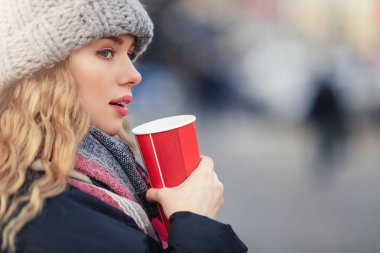 Kadın sokakta yürürken onu sıcak kahve iç. Kışın şık gülümseyen kadın portresi sıcak kahve içme giysiler. Kadın kış Style. -Görüntü