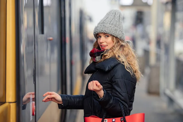 妇女按住她的红包 而打开电车 时尚微笑的女人在冬季服装持有袋的肖像 女性冬季风格 图片仅供参考 — 图库照片