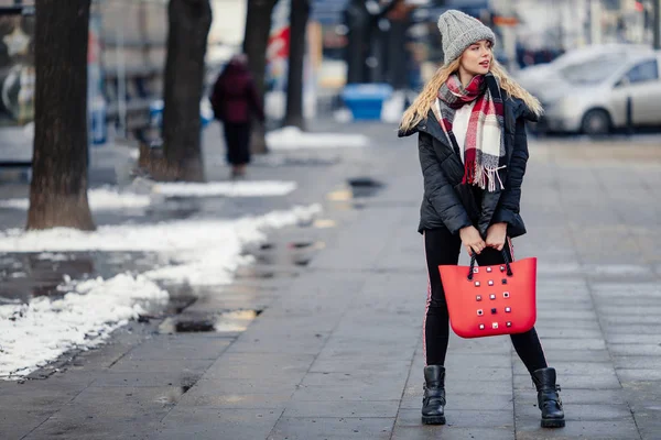 女性は 彼女の赤いバッグを押しながら通りを歩いてします 冬服袋を保持でスタイリッシュな笑顔の女性の肖像画 女性の冬のスタイル イメージ — ストック写真