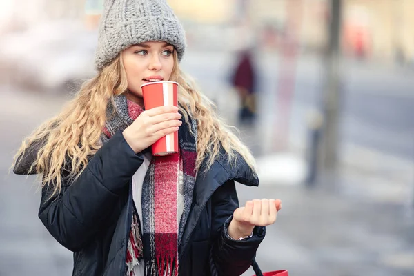 女人在街上散步时喝她的热咖啡 时尚的微笑的女人在冬季衣服的肖像喝热咖啡 女性冬季风格 图片仅供参考 — 图库照片