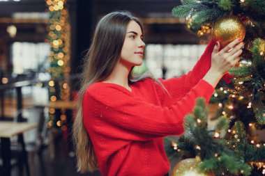 Güzel kız giyim kırmızı, enjoing zamanının kapalı Noel evle ışıklar. Kopya alanı
