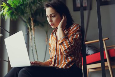 İş kadını ofiste merdivenlerde otur, iş üstünde laptop ve yeni fikirler hakkında düşünüyorum. İş için kopya alanı dizüstü bilgisayar kullanan kız