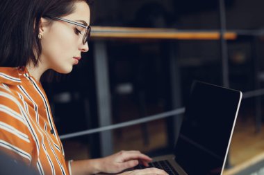 İşkadını giyim gözlük ofis, iş üstünde laptop ve kalem ile yeni fikirler hakkında düşünüyorum. İş için kopya alanı dizüstü bilgisayar kullanan kız