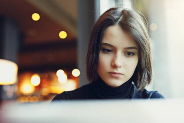 Kadın etrafına bakmak ve Cafe çalışmalarında ise onu Laptop gülümse. Kış giysileri içinde şık gülümseyen kadın portresi Laptop iş. Güneş - görüntü stiliyle kadın Bussiness