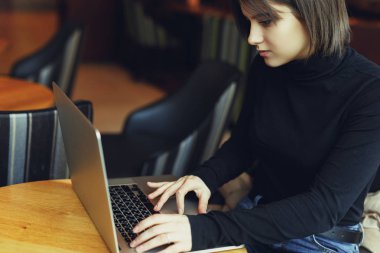 Kadın etrafına bakmak ve Cafe çalışmalarında ise onu Laptop gülümse. Kış giysileri içinde şık gülümseyen kadın portresi Laptop iş. Güneş - görüntü stiliyle kadın Bussiness