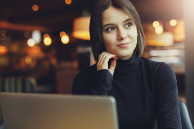 Kadın etrafına bakmak ve Cafe çalışmalarında ise onu Laptop gülümse. Kış giysileri içinde şık gülümseyen kadın portresi Laptop iş. Güneş - görüntü stiliyle kadın Bussiness