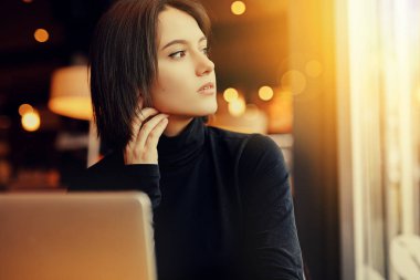 Kadın etrafına bakmak ve Cafe çalışmalarında ise onu Laptop gülümse. Kış giysileri içinde şık gülümseyen kadın portresi Laptop iş. Güneş - görüntü stiliyle kadın Bussiness