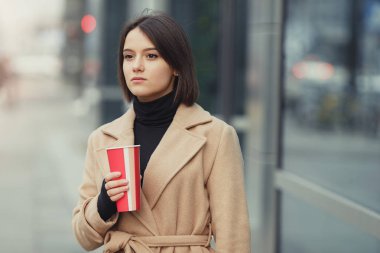 Kadın sokakta yürürken onu sıcak kahve iç. Kışın şık gülümseyen kadın portresi sıcak kahve içme giysiler. Kadın kış Style. -Görüntü