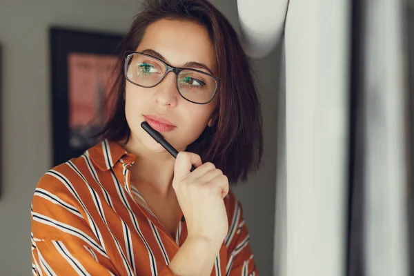 Businesswoman wear glasses in office, draw plan on the desk and think about new ideas with pen. Girl using pen for draw, copy space