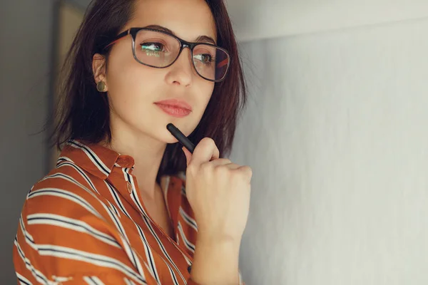 Businesswoman wear glasses in office, draw plan on the desk and think about new ideas with pen. Girl using pen for draw, copy space