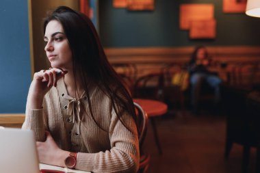 Oldukça esmer kadın onun işi kafede, gözlük ve dizüstü pencerenin yakınındaki bir sohbet. -Görüntü