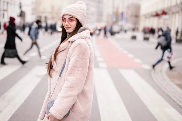 Fashion woman walking on the city street, wear pantone color jaket with pink glasses and look to camera. Copy space. - Image