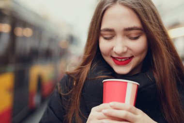 Kadın sokakta yürürken onu sıcak kahve iç. Kışın şık gülümseyen kadın portresi sıcak kahve içme giysiler. Kadın kış Style. -Görüntü
