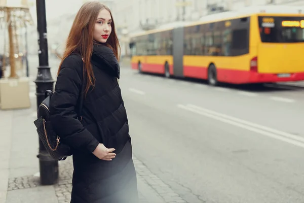 漂亮的女孩在有复制空间的城市街道上等着她的公交车 图片仅供参考 — 图库照片