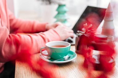 Kırmızı çay ve diz üstü Cafe, yeşil çay, bitki, ekran, eller, çalışan adam.
