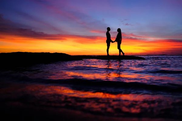 Arka plan renkli batımında sahilde romantik çift