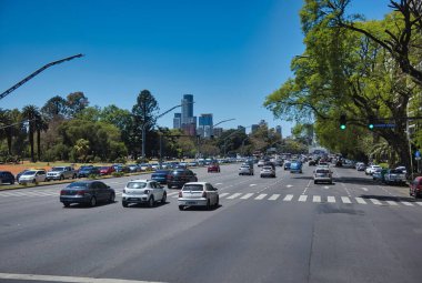 Buenos Aires, Arjantin, 04 Kasım 2022: Buenos Aires 'teki Avenida de Libertador boyunca yoğun kentsel karayolunu çevreleyen gür ağaçlarla trafik akışı.