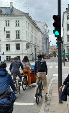 Kopenhag, Danimarka - 24 Temmuz 2023: turistler ve bisikletçiler şehir merkezindeki tarihi binaların önünden geçiyor