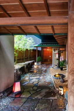 Tokyo, Japonya - 25 Kasım 2012: Taş yolları fenerleri ve canlı yeşilliklerle dolu geleneksel bir Japon bahçesinden geçen sakin bir patika..