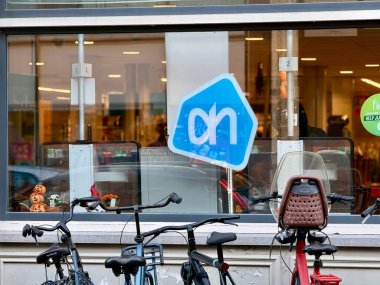 Den Haag, Hollanda - 24 Ekim 2024: Den Haag 'daki Albert tavuk süpermarketinin önünde park etmiş bisikletler.