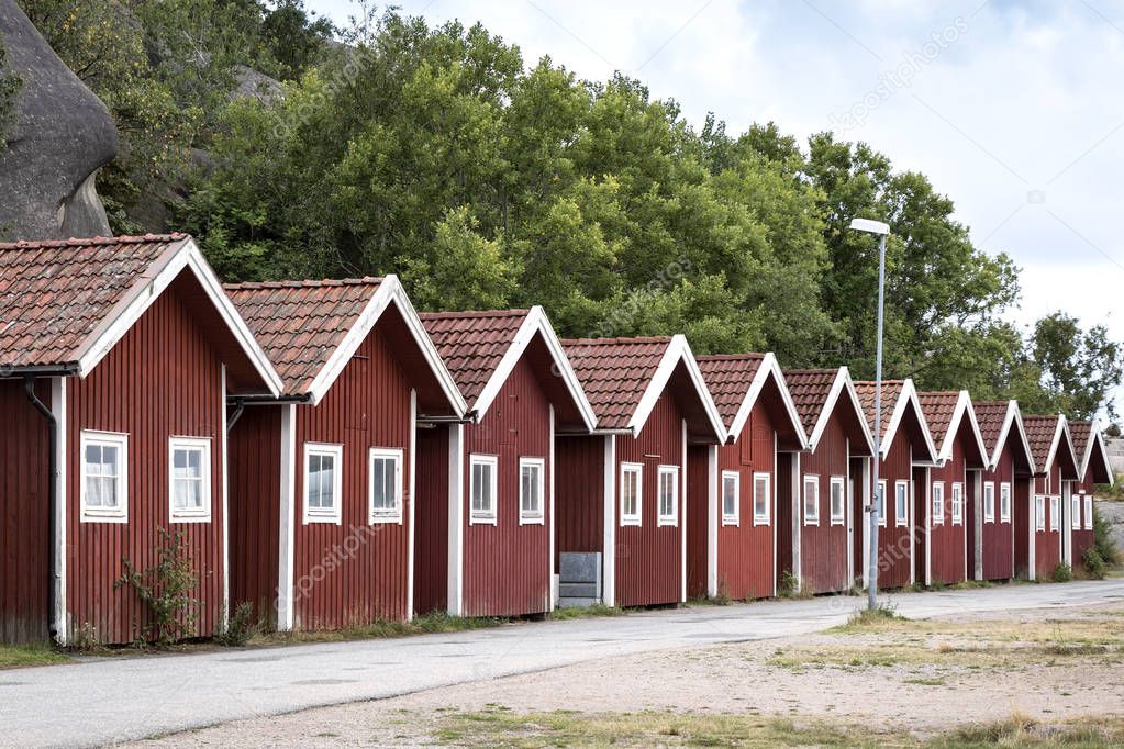 Traditional boathouses are located in a small harbor, Sweden