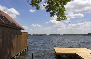 Güneşli günler, göldeki kayıkhane, Mecklenburg,