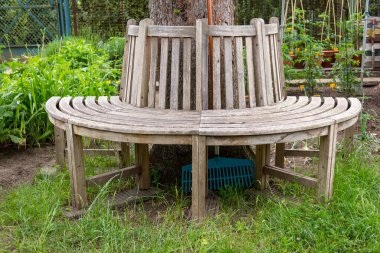 Tahta bir bahçede ahşap bir bank manzarası. Dinlenmek için harika bir yer yaratıldı..