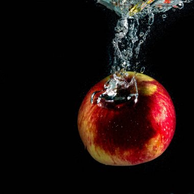 kırmızı olgun Elma sıçramaları ile suya düşüyor