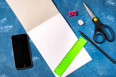 mavi arka plan üzerinde çizim pedi ve renkli kalemler