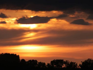 Gün batımında parlak güneş ışığı olan kara bulutlar.