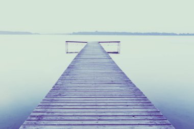 Gölde gündoğumu sırasında eski boş ahşap iskelesi.