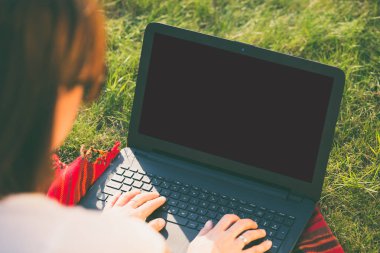 Kadın Parkı veya bahçede oturan ve onu laptop yazarak.