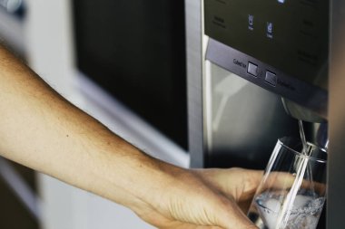 Erkek el ev buzdolabı Klozette dispenser soğuk su ve buz yağıyor.