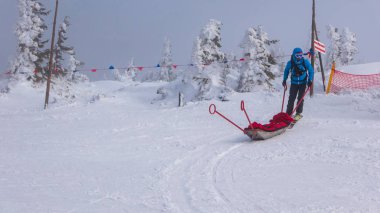 Kurtarma ekibi slayt sedye ile Kayak, kötü hava koşulları sırasında kayak yapmak yardım getiriyor.