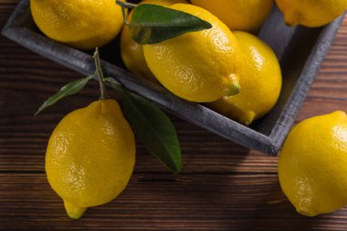 Taze sarı limon yaprakları ile ahşap bir masaya yalan. 